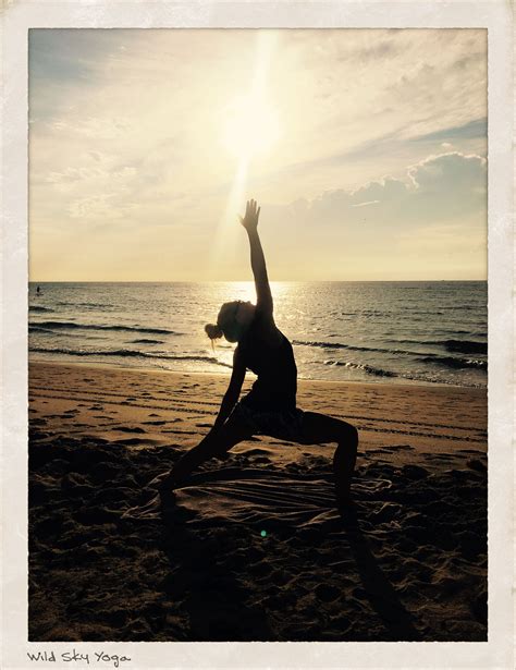A Woman Doing Yoga On The Beach At Sunset