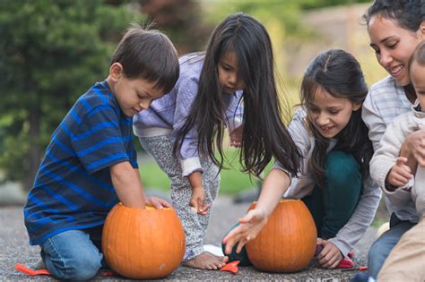 Multiethnic Group Of Kids Carving Pumpkins Stock Photo Download Image