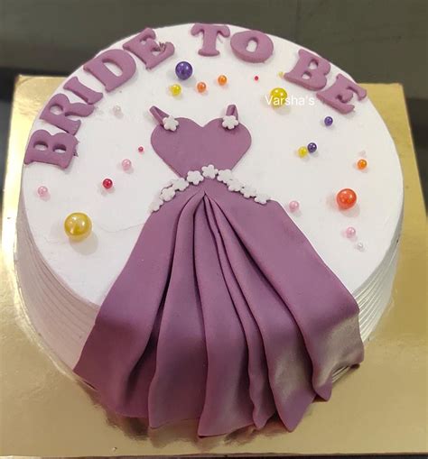 A Cake Decorated With Purple And White Icing On A Gold Platter That