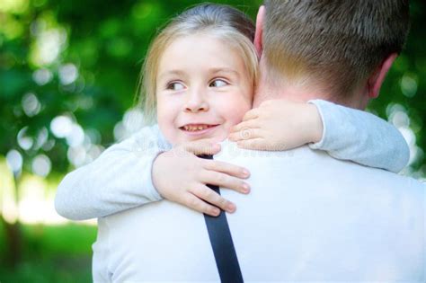 Niña Adorable Feliz Que Abraza Abrazando A Su Padre Imagen De Archivo