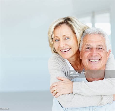 Happy Mature Lady Hugging Her Husband From Behind High Res Stock Photo