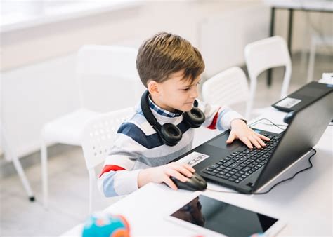 Un Niño Pequeño Que Usa La Computadora Portátil En El Escritorio En El