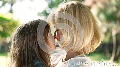 Side View Close Up Happy Loving Mother And Babe Rubbing Noses Hugging In Sunshine Outdoors