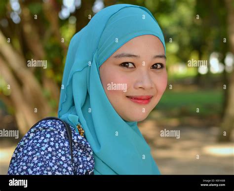 Beautiful Young Muslim Woman From Malaysia Wearing A Stylish Turquoise Hijab Throwing The