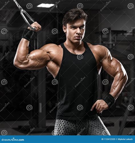 Muscular Man Working Out In Gym Doing Exercises Strong Male