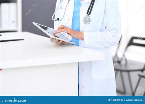 Close Up Of Female Physician Using Digital Tablet While Standing Near