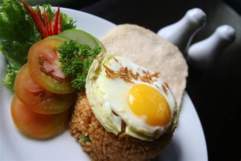 Nasi Goreng Fried Rice With Shrimps And Egg Garnished With Fresh Cucumber Slices And Prawn