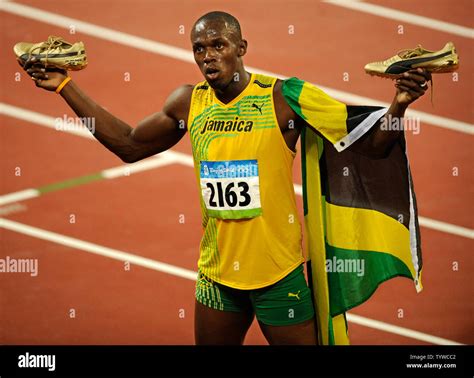 jamaica s usain bolt holds up his golden shoes after setting a world record of 9 69 seconds in