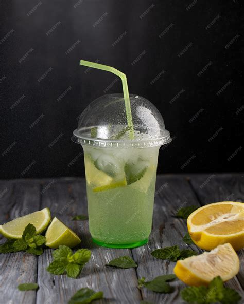 Premium Photo Lemonade In A Plastic Cup And Lemon With Mint On The