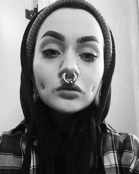 A Woman With Piercings On Her Nose And Nose Ring