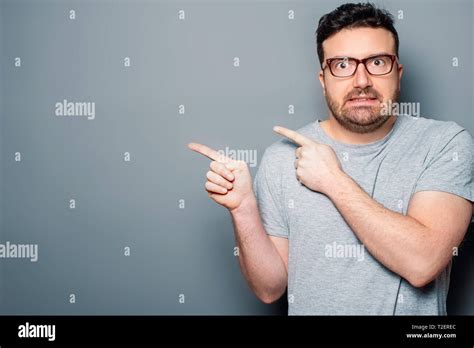 Man Shocked And Surprised Pointing Away And Looking At Camera Stock