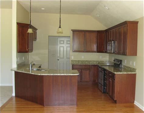 From the quarries of sao paolo, brazil, and named after a martyr in the christian church, santa cecilia is among the most popular granites. cherry kitchen cabinets with granite | The kitchen's cherry cabinets and granite countertops ...
