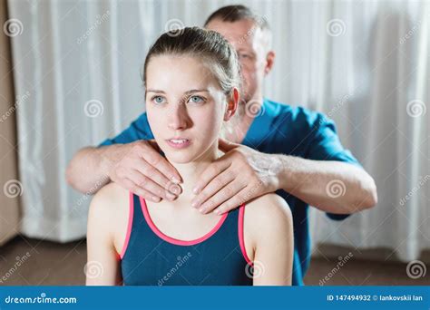 Male Manual Visceral Therapist Masseur Treats A Young Female Patient Warm Up The Shoulders And