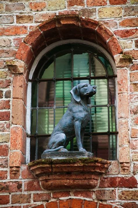 Sitting Dog Statue Monument Vintage Red Brick Wall And Colorful Window