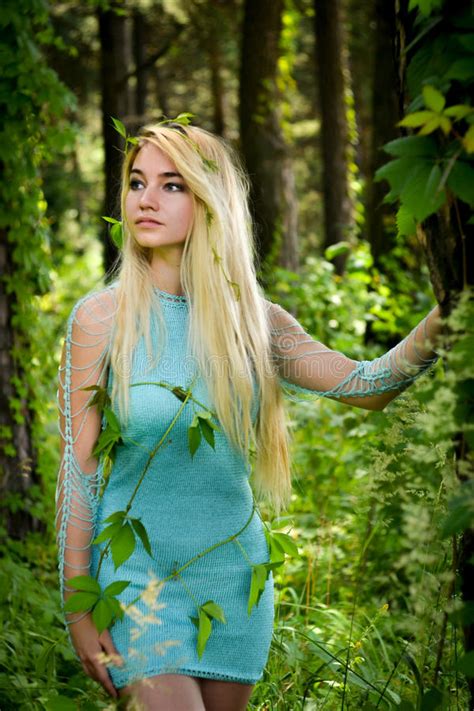 Pretty Young Blonde Girl With Long Hair In Turquoise Dress Standing In