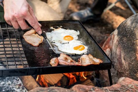Breakfast Camp Cooking Grilling Crispy Bacon And Eggs On A Cast Iron