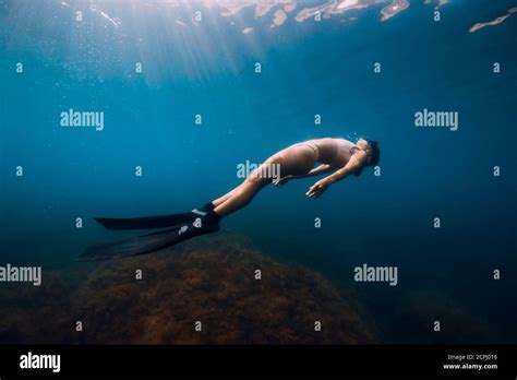 Free Diver Glides With Fins Under Sea Woman Is Doing Freediving In The