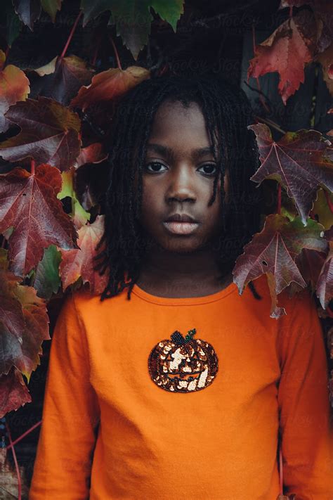 African American Girl Standing In Front Of A Wall Covered With Ivy By