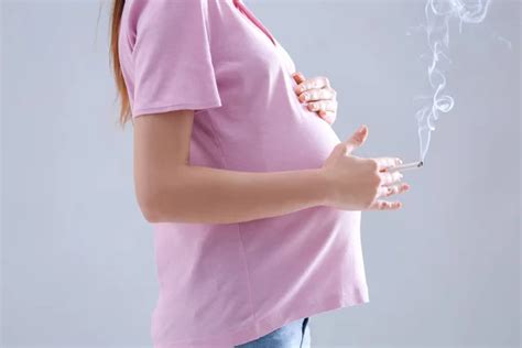 Mujer embarazada fumando cigarrillo fotografía de stock belchonock