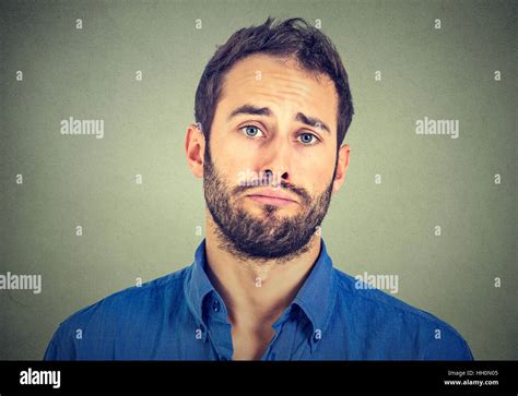 Portrait Of Sad Young Man Isolated On Gray Wall Background Stock Photo