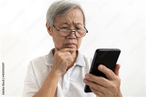 Confused Asian Senior Woman With Puzzled Looks Holding Smartphone