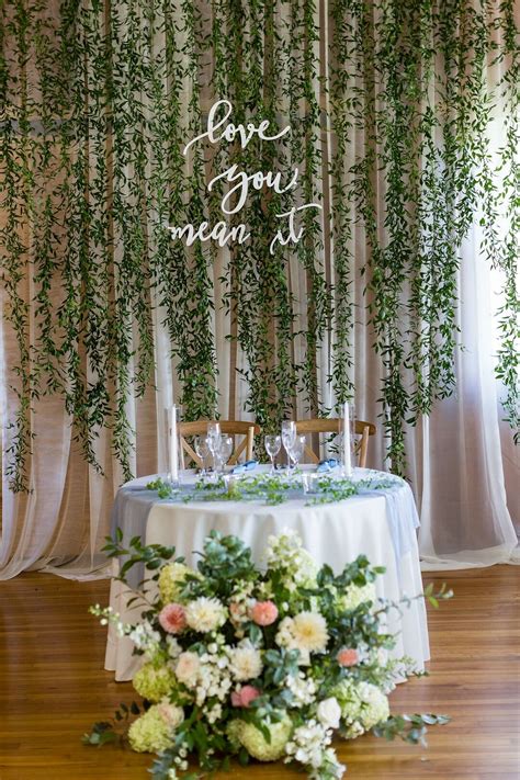 Classic Sweetheart Table With Hanging Greenery And Flower Arrangement