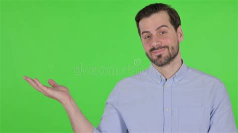 Portrait Of Man Holding Product On Hand Green Screen Stock Photo