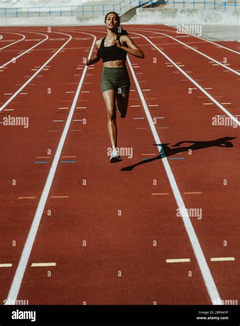 Female Athlete Sprinting On A Running Track In A Track And Field