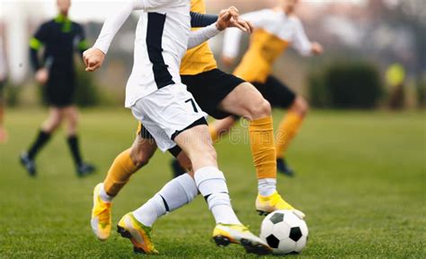 Adult Football Competition Soccer Football Player Dribbling A Ball And