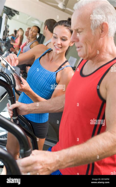 Personal Trainer Instructing Man On Treadmill Stock Photo Alamy