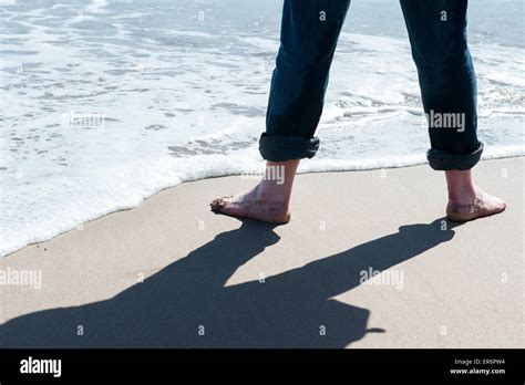 Mann Auf Einem Strand Am Meer In Nackten Füßen Wirft Einen Schatten In Der Sonne Uk