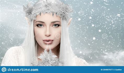 Winter Queen Gorgeous Woman With Snow Queen Costume Blowing Magic Icy