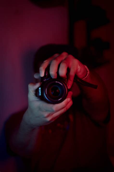 Man with photo camera in dark studio · Free Stock Photo