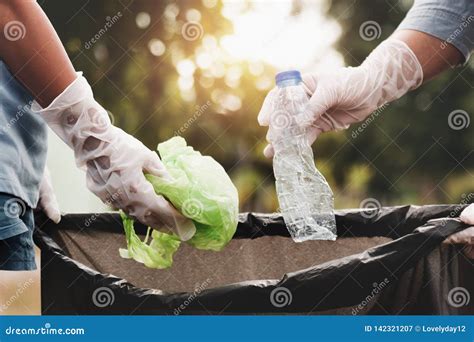 Hand Picking Up A Clear Plastic Bottle Drop On The Ground With Polluted