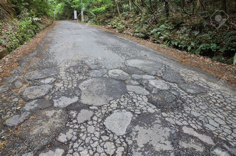 Damaged Road In Japan Cracked Asphalt Blacktop With Potholes