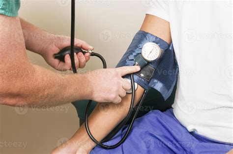 A Clinician In The Process Of Conducting A Blood Pressure Examination