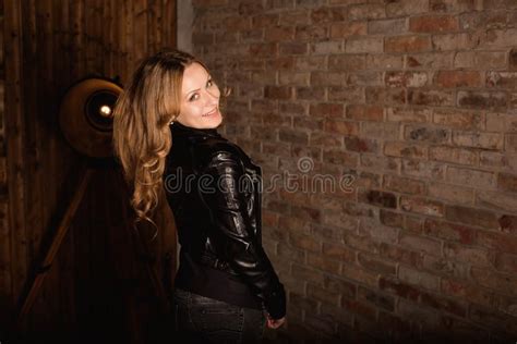 Fashion Model In A Black Leather Jacket Posing Near Brick Wall Stock