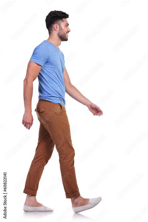 Side View Of A Casual Man Walking Forward And Smiling Stock Photo