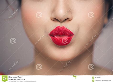 Woman`s Lips Blowing A Kiss With Bright Red Lipstick Stock Image