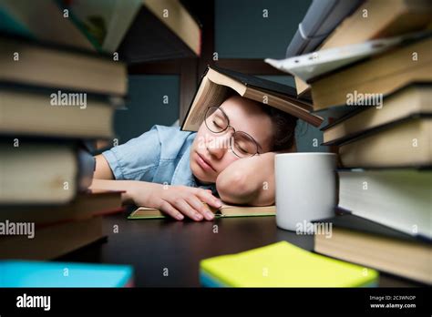 A Young Student Girl Fell Asleep On A Book Hiding Behind Another Book