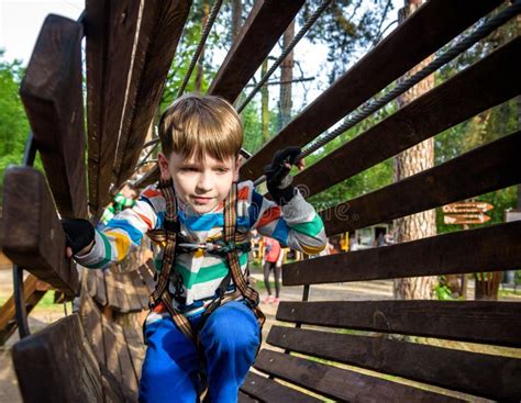Happy Kid Overcomes Obstacles In Rope Adventure Park Summer Holidays
