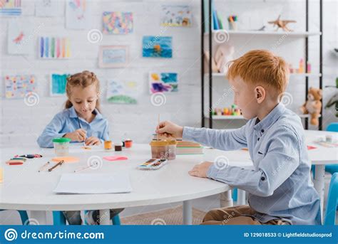 Portrait Of Cute Preschoolers Drawing Pictures With Paints And Paint