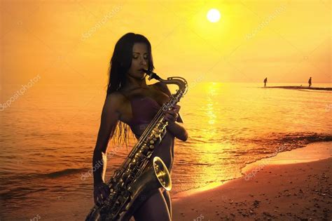 Женщина играет на саксофоне на пляже стоковое фото ©bareta 118289906