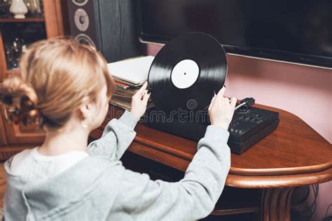 Young Woman Listening To Music From Vinyl Record Player Retro And