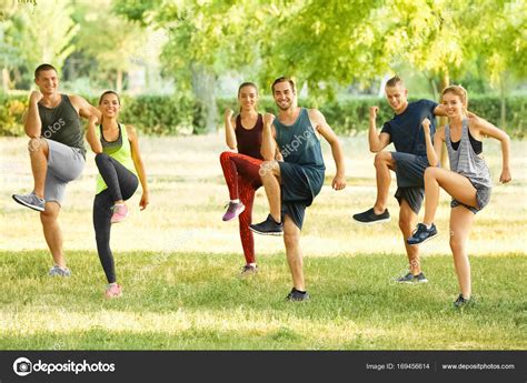Group Of Young People Doing Exercise Outdoors Stock Photo By