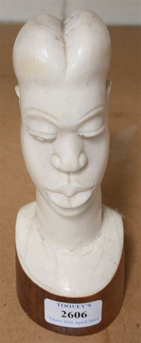 A 20th Century African Carved Ivory Portrait Head Of A Woman On An