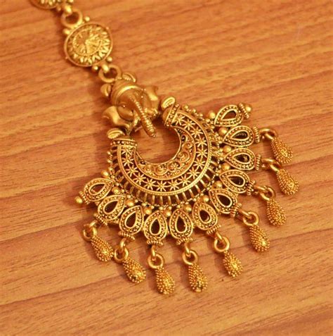 Buy gold maang tikka for women and gift your woman the most exotic jewel. Gold maang-tikka - Sanvi Jewels Pvt. Ltd. - 2995204