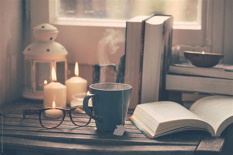 Still life of used books, tea time, glasses and candles on a wood table