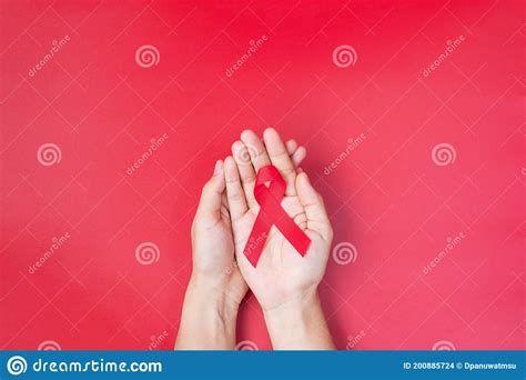 Hand Holding Red Ribbon For Supporting People Living And Illness