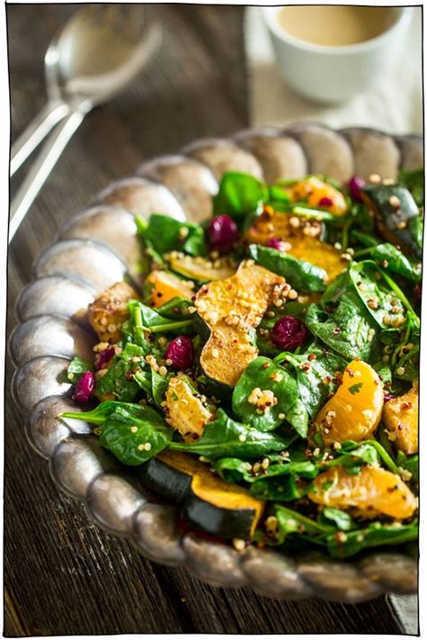 A Salad With Spinach Oranges And Cranberries In A Bowl